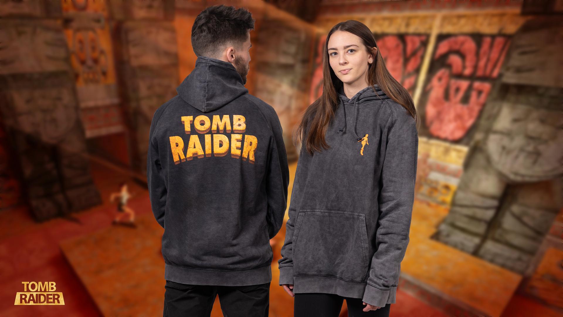 The Tomb Raider Play For Sport Hoodie, a black tie-dyed pullover feat. a silhouette of Lara Croft embroidered on the front, and the game’s logo printed on the back.