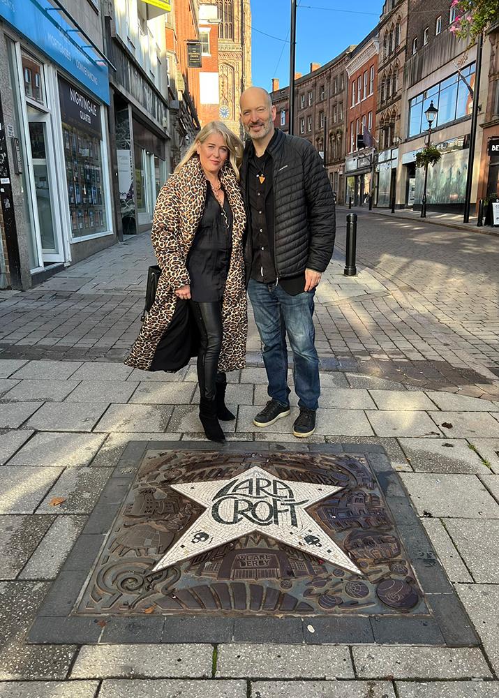 Jonell Elliott (Lara Croft VA) and Eric Loren (Kurtis Trent VA) posing with the Lara Croft cast iron plaque in Derby, UK. Photo by Raidercast
