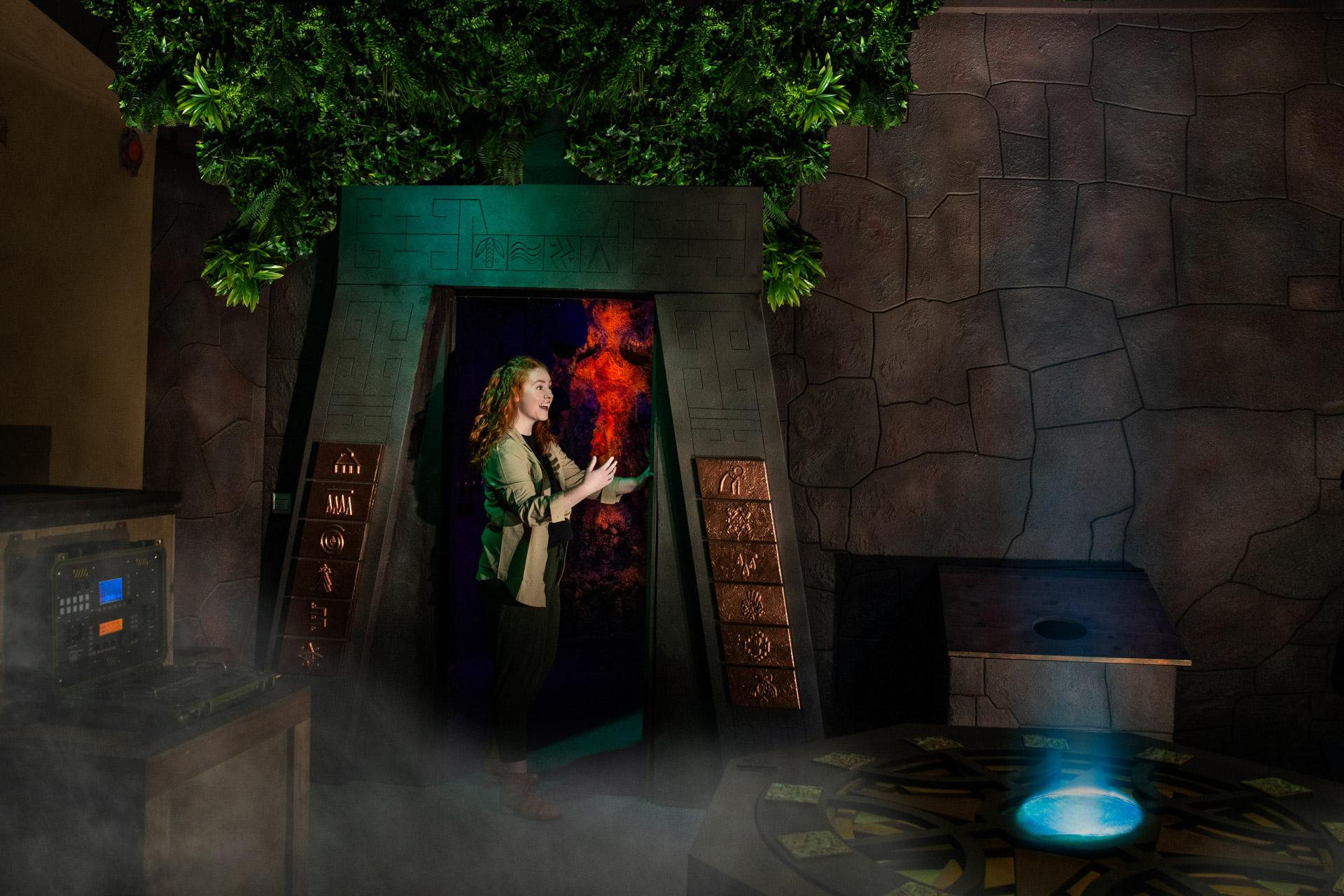 Woman exploring tomb at Tomb Raider Experience Seattle