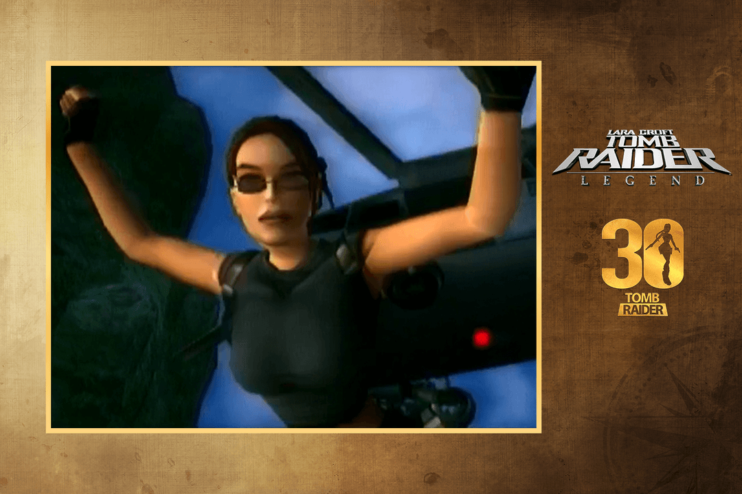 Promotional image featuring Lara Croft from Tomb Raider: Legend climbing with both arms raised inside a dimly lit environment. Lara wears a black sleeveless top, fingerless gloves, and dark sunglasses, with holstered gear visible at her sides. The image appears as a low-resolution in-game screenshot framed by a gold border on a textured brown background. To the right are the “Lara Croft Tomb Raider: Legend” logo and a gold “30 Tomb Raider” anniversary emblem.