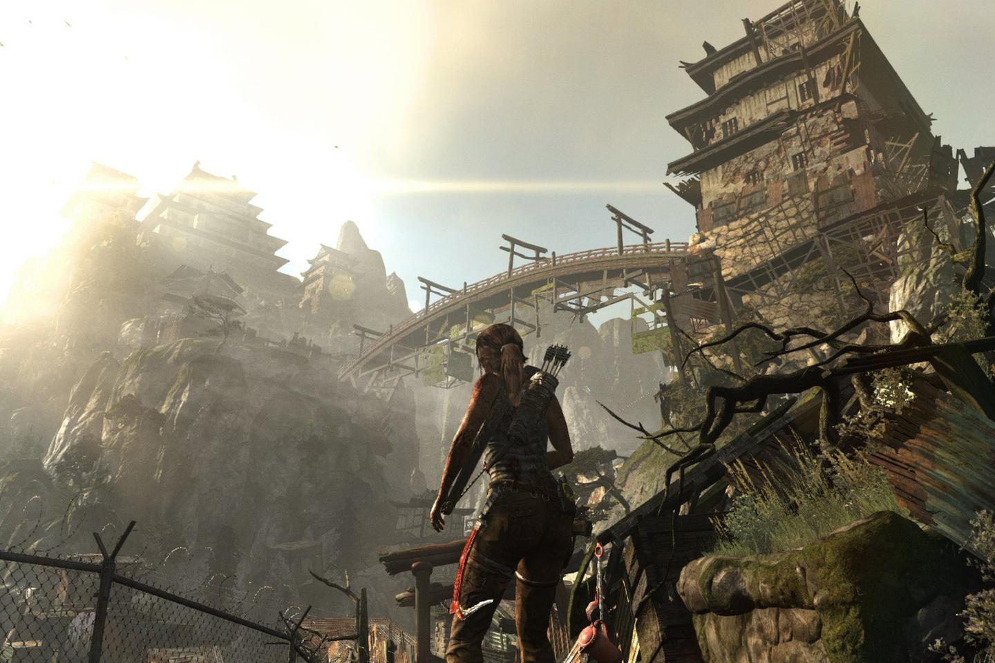 Lara standing below tomb bridge cast in sunlight.