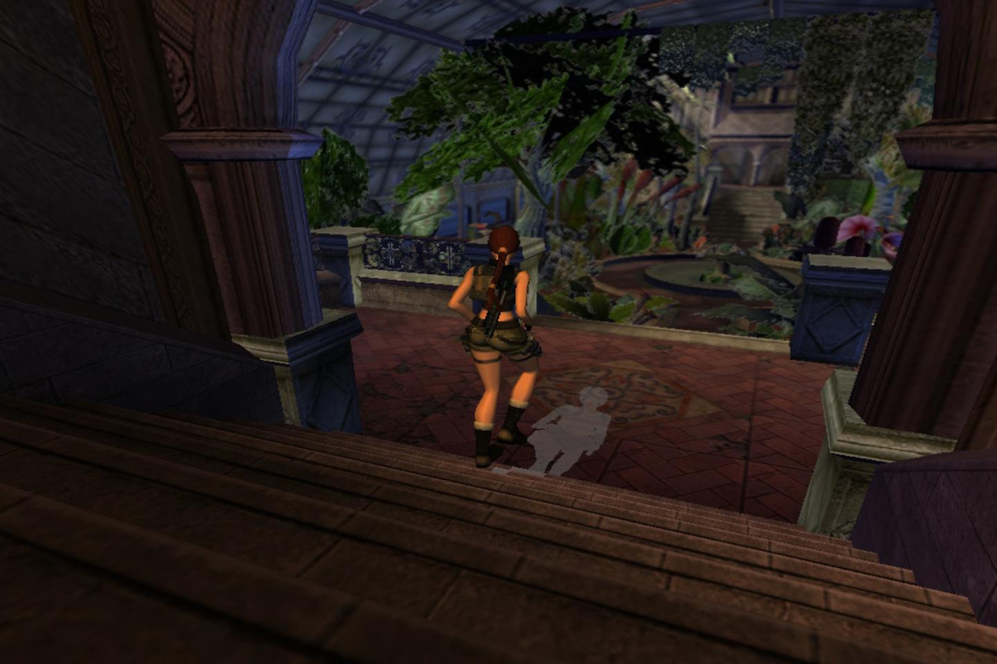 Lara walking down stairs toward interior pond and trees.