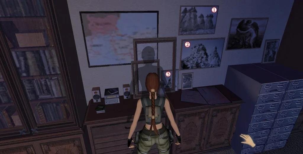 A video game screenshot showing the character Lara Croft in a room with pictures and artifacts on the wall, representing a research or study area.