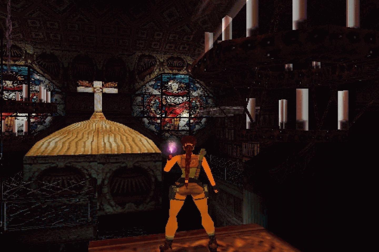 Lara stands in church facing cross and colorful stained glass windows.
