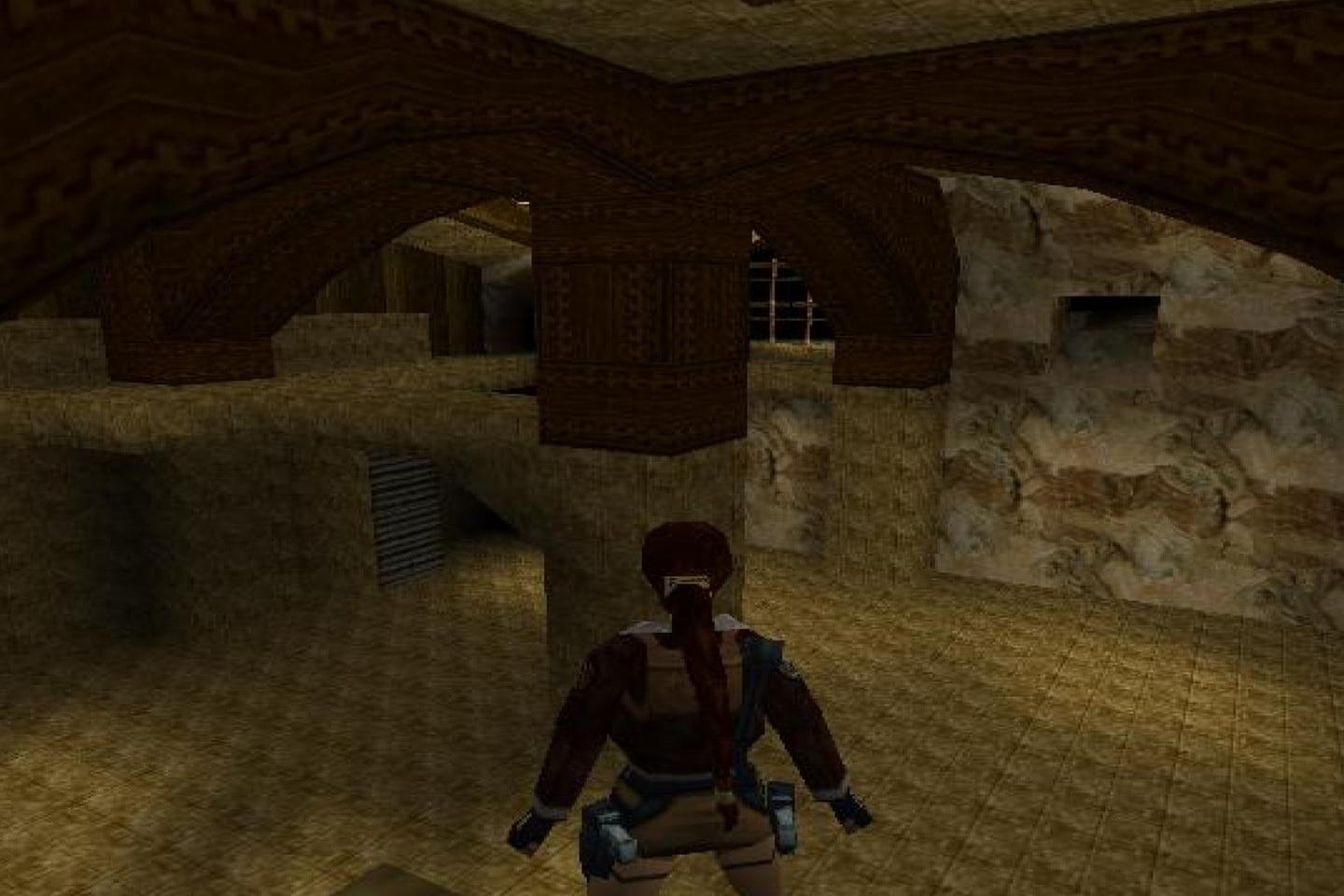 Lara wearing padded gear in dimly lit tomb